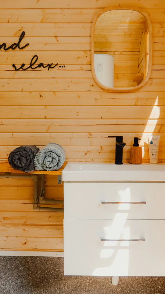 Waschbecken im Sanitärfass mit Handtüchern und Pflegeprodukten
