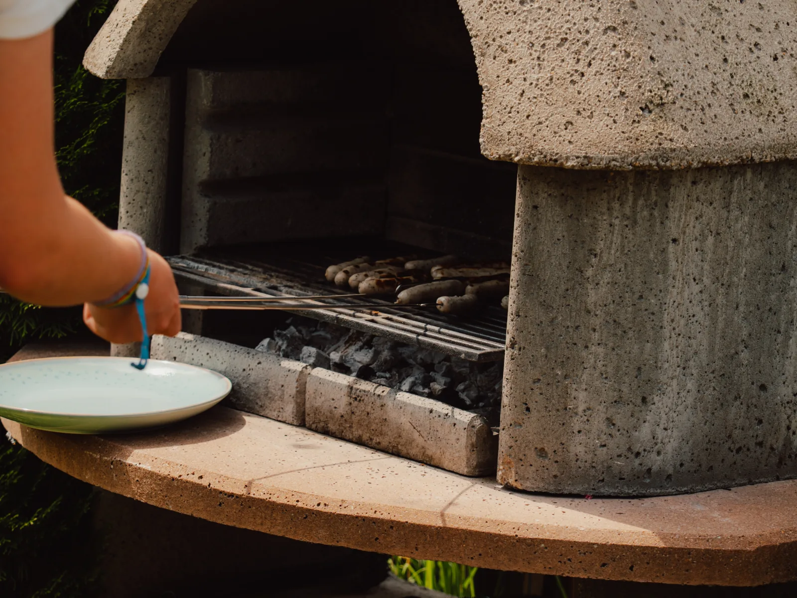 Grillen am Holzkohlegrill mit Grillzange