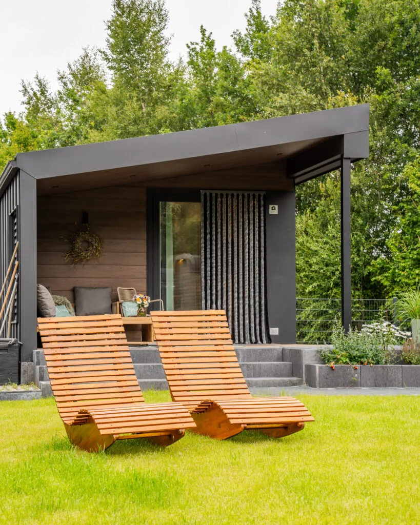 Überdachte Terrasse mit Holzbank vor dem Eingang