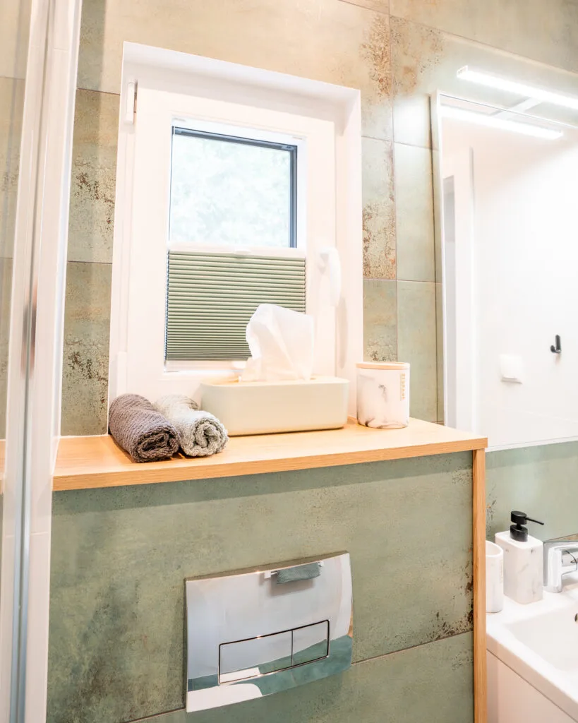 Badezimmer mit gerollten Handtüchern am Waschtisch