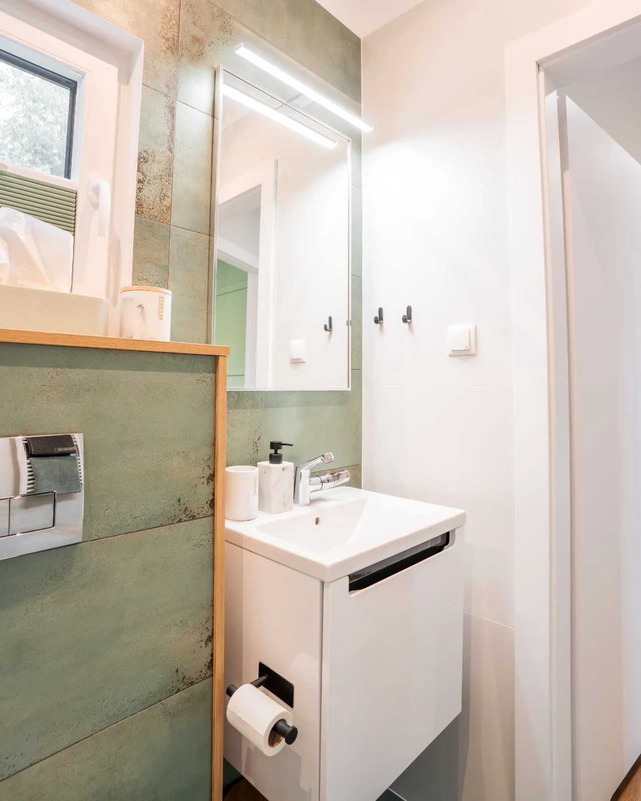 Badezimmer mit Waschbecken, Spiegel und Dusche
