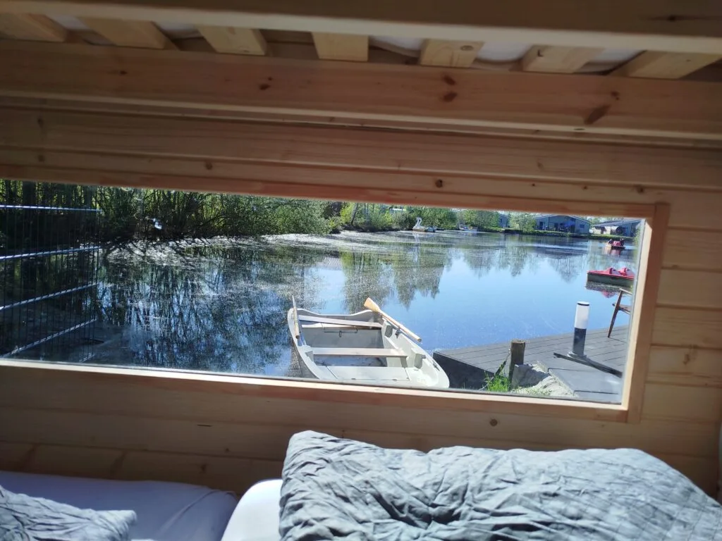 Panoramafenster mit Blick auf See und Ruderboot