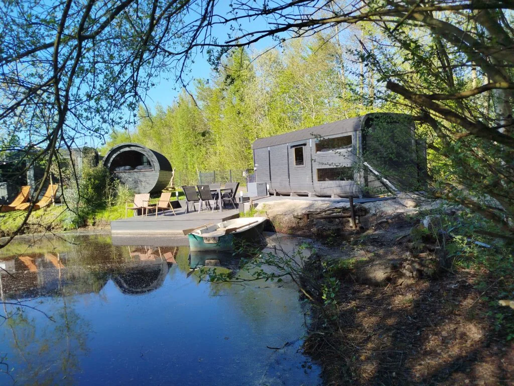 Blick über den See auf Schlaffass, Tinyhouse und Steg