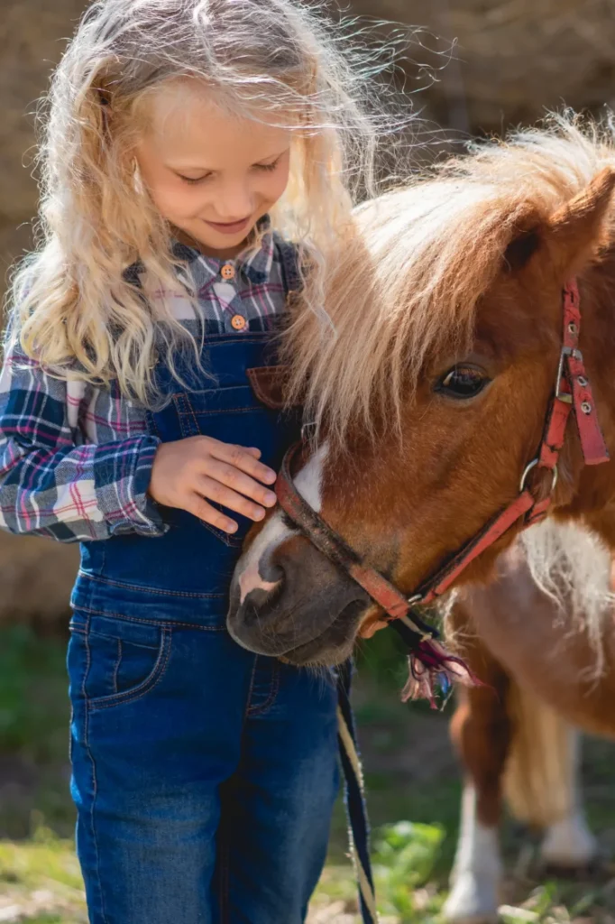 Mädchen streichelt ein Pony